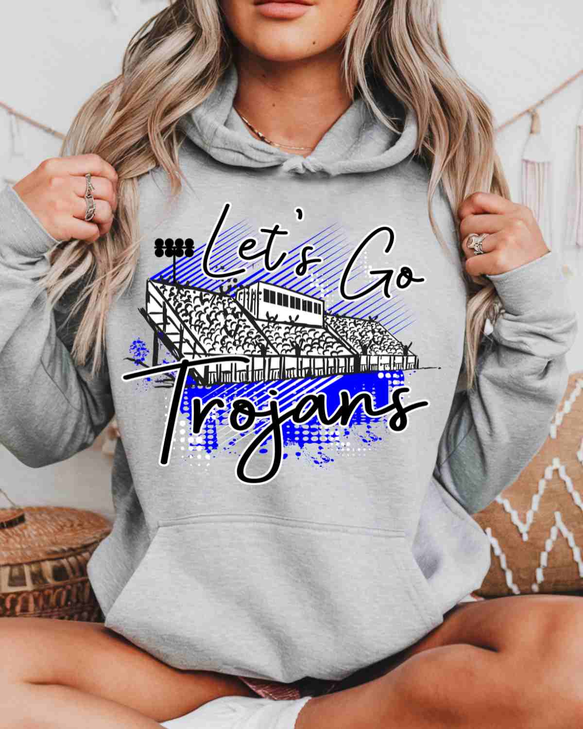 Person wearing a gray hoodie with 'Let's Go Trojans' text and graphic design.